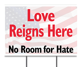 Rectangular lawn sign, faded flag background, red letters say love reigns here, below black letters say no room for hate.